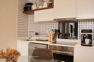 a kitchen with white cabinets and a glass table at Condo in Sandton Masingita Tower in Johannesburg