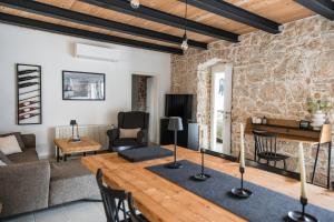 - un salon avec un mur en pierre et une table en bois dans l'établissement Villa Verde Višnjan, à Višnjan