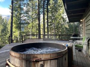 a hot tub on the deck of a house at Culps Cascade | Wi-Fi, Woodstove, Cedar Hot tub in Packwood