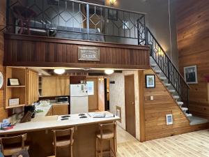 a kitchen with a staircase and a kitchen island with chairs at Culps Cascade | Wi-Fi, Woodstove, Cedar Hot tub in Packwood