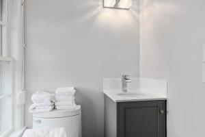 a white bathroom with a sink and a toilet at Capacious North Truro Beachfront Home in Provincetown +54 photos