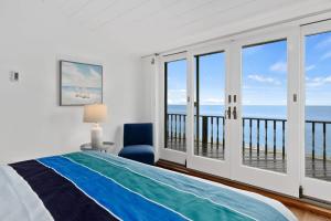 a bedroom with a bed and a view of the ocean at Capacious North Truro Beachfront Home in Provincetown