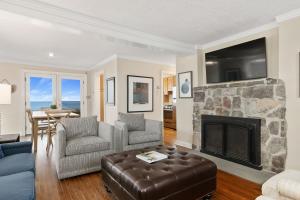 a living room with a fireplace and a tv at Capacious North Truro Beachfront Home in Provincetown