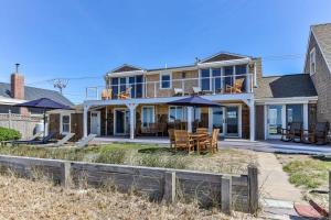 a house on the beach with a table and chairs at Capacious North Truro Beachfront Home in Provincetown