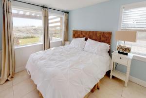 a white bedroom with a bed and a window at Cottage Four DIRECT OCEANFRONT Romantic Cottage Best Beach - Walk to Restaurants - Downtown only 5 Miles in Saint Augustine Beach