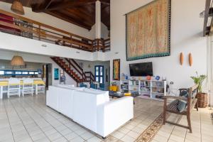 a living room with a couch and a tv at Casarão de vidro - Pé na Areia - Praia Enseada dos Corais in Cabo de Santo Agostinho
