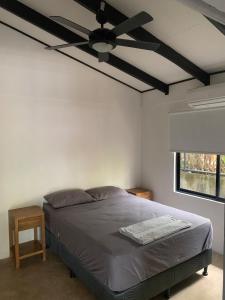 Un dormitorio con una cama con ventilador de techo. en Aduana - Beach House, en Santa Teresa Beach