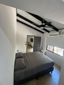 Un dormitorio con una cama y un ventilador de techo. en Aduana - Beach House, en Santa Teresa Beach 18 fotos más