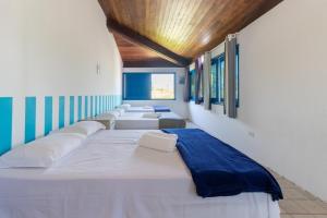 a row of beds in a room with windows at Casarão de vidro - Pé na Areia - Praia Enseada dos Corais in Cabo de Santo Agostinho +62 photos