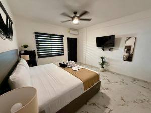 a bedroom with a large bed with a ceiling fan at CASA TORTUGA 5Th Ave in Playa del Carmen