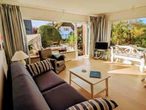 a living room with a couch and a table at Haus Hanne Sylt Wohnung Erdgeschoss in Sylt
