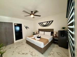 une chambre avec un lit et un ventilateur de plafond dans l'établissement CASA TORTUGA 5Th Ave, à Playa del Carmen