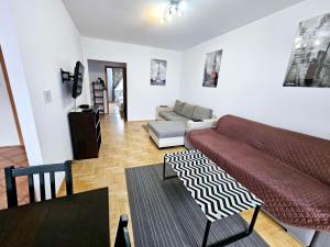 a living room with a couch and a table at Green Kabaty Apartment 2 in Warsaw