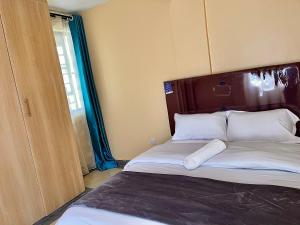 a bedroom with a large bed with white pillows at Bella Homes Thika Town in Thika