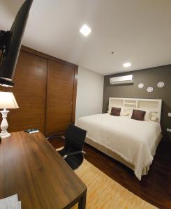 a bedroom with a bed and a desk with a chair at Casa Garay Hotel 658 in Asuncion
