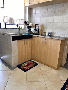 a kitchen with a sink and a kitchen rug on the floor at Bella Homes Thika Town in Thika +10 photos
