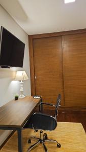 a office with a desk and a chair with a lamp at Casa Garay Hotel 658 in Asuncion