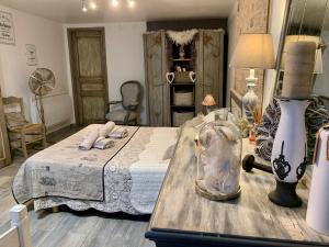 ein Schlafzimmer mit einem Bett und einem Tisch mit einer Lampe in der Unterkunft Les pondres en vaunage in Caveirac + 53 Fotos