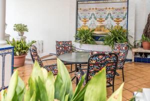 einen Tisch und Stühle in einem Zimmer mit Pflanzen in der Unterkunft La Casa de la Cascada in Anna