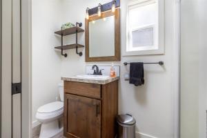 a bathroom with a toilet and a sink and a mirror at Glacier Peak Getaway | Wifi, Fireplace, Lower Timb in Packwood +24 photos