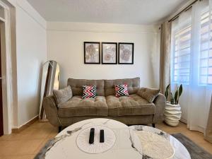 a living room with a couch and a table at Tranquil Luxury Stay, Utawala, JKIA View in Nairobi
