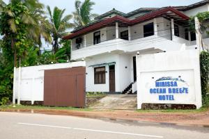 Biały dom z napisem "Mission Ocean Drive Hotel" w obiekcie Mirissa Ocean Breeze Hotel Triple room w mieście Mirissa