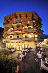 un hotel con tavoli e sedie di fronte a un edificio di Sporthotel Kirchler a Tux
