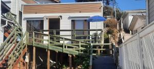 una casa pequeña con terraza y sombrilla en Cabañas junto a la playa, en Las Cruces