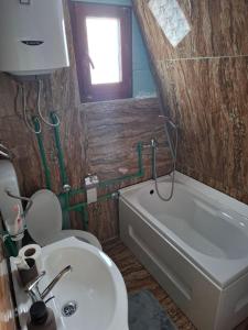 a bathroom with a toilet and a sink and a tub at Forest Heaven in Kolašin +16 photos