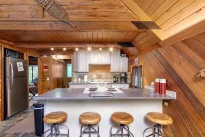 a kitchen with wooden ceilings and a counter with stools at Elk Drop Inn | Wifi, Firepit, Smart TV in Packwood