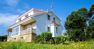 a white house on a hill with a field of flowers at Casa Olivar El Mandarino in Orazo