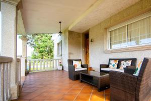 a porch with chairs and a couch and a table at Casa Olivar El Mandarino in Orazo