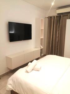 a bedroom with a bed with a tv on the wall at Bark Luxury Apartments @The Signature in Accra +24 photos