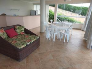 a living room with a couch and a table and chairs at Casa Nascer do Sol- Iriri-ES in Anchieta