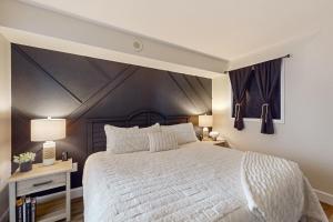 a bedroom with a large white bed and two tables at Sandy Daydreams, Unit PH3 in Myrtle Beach +29 photos