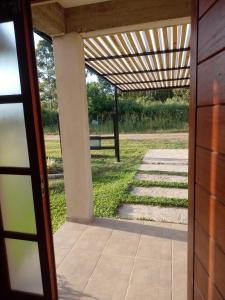 eine offene Tür zu einer Terrasse mit einer Pergola in der Unterkunft Santa María alojamiento in Federación