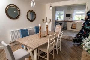 a dining room with a table and a christmas tree at -- Huge -- 5-bedroom home & Private Gym by Tailored Accommodation in Swansea
