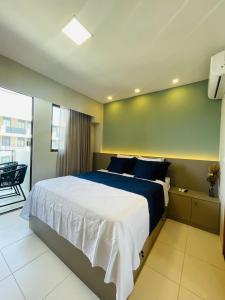 sypialnia z dużym łóżkiem i balkonem w obiekcie MALIA BEACH - Alto Padrão - PRAIA MURO ALTO - Porto de Galinhas w mieście Porto de Galinhas