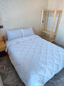 a large blue bed in a room with a wooden ladder at Sea Breeze in Imsouane