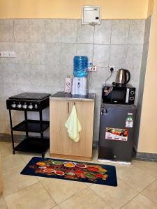 a kitchen with a counter with a stove and a refrigerator at Bella Homes 2br Thika Town in Thika +10 photos