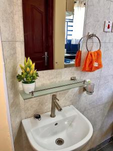 a sink in a bathroom with a mirror and a mirror at Bella Homes 2br Thika Town in Thika