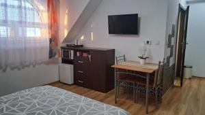 a bedroom with a bed and a table and a television at Noclegi Damianek in Nowy Targ