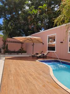a swimming pool with a wooden deck next to a house at Casa Garay Hotel 658 in Asuncion