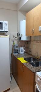 een kleine keuken met een spoelbak en een koelkast bij Tres Ciudades in Monte Hermoso