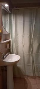 een badkamer met een wastafel en een douchegordijn bij Tres Ciudades in Monte Hermoso