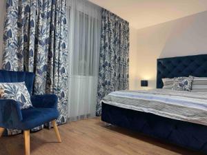 a bedroom with a bed and a blue chair at Tsvetanov Apartment in Blagoevgrad