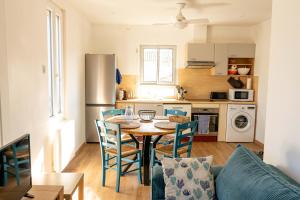 a kitchen and dining room with a table and chairs at Appartement avec piscine et jacuzzi à 50mètres de la plage et 5min de l'allée des Pins in Argelès-sur-Mer