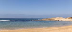 a sandy beach with the ocean in the background at superbe appartement famille in Oualidia +26 photos