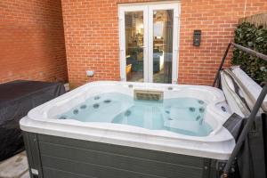 a jacuzzi tub sitting in a yard at A Swansea Getaway - 3 Bedroom Home with Hot Tub in Swansea +53 photos