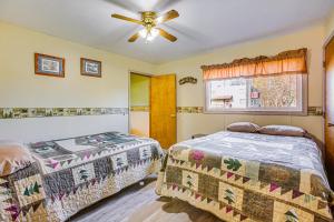 a bedroom with two beds and a ceiling fan at Michigan Manistee River Cabin about 1 Mi to Downtown in Manistee